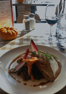 Plat (viande et champignons) du restaurant La Salle à Manger Les Apprentis d'Auteuil avec un verre de vin rouge